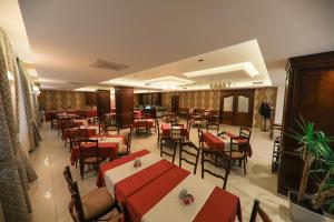 a restaurant with red and white tables and chairs at Hotel Kacinari in Prizren