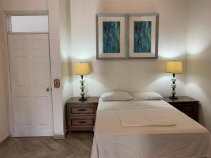 a bedroom with a bed and two lamps and a door at Palmira Hostel in Tegucigalpa