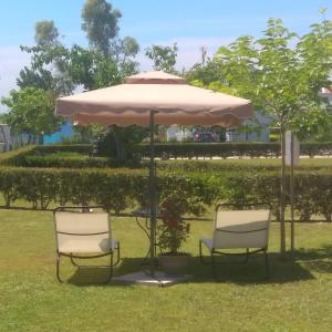 Villa Nadia في نيا سكيوني: طاولة و كرسيين تحت مظلة