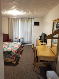 a hotel room with a bed and a desk with a computer at Knights Inn Woodstock in Woodstock