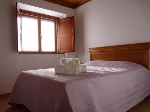 a bedroom with a bed with two towels on it at Refugio da Ti Maria in Batalha