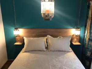 a bedroom with a bed with two pillows and two lights at apart Italia in Río Cuarto