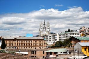 a view of a city with buildings and a clock tower at Hostal Brilliant in Quito