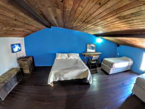 a room with a blue wall and a bed and a desk at Departamento Centro de Búzios in Búzios