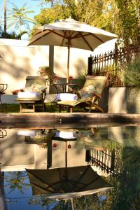 a reflection of a table and an umbrella and chairs at Cafe Felix & Old Oak Manor in Riebeek-Kasteel