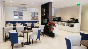 um restaurante com cadeiras e mesas brancas e azuis em Porto City Hotel em Porto