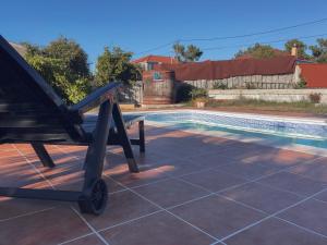 uma cadeira sentada num pátio ao lado de uma piscina em Casa Idalia em Ourense