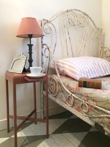 a bed with a table with a lamp and a cup on it at The Broken Dish - Full Cottage Apartment in Mendham
