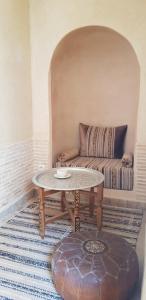a living room with a table and a couch at Riad Dar Haven in Tamraght Ou Fella