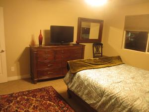 ein Schlafzimmer mit einem Bett und einem TV auf einer Kommode in der Unterkunft Super Large Art Museum in Downtown Scottsdale in Scottsdale