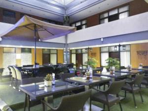 a restaurant with tables and chairs in a building at Hotel Victory Bandung in Bandung