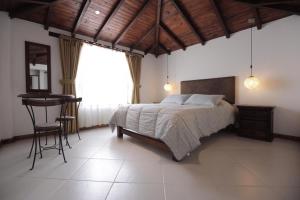 ein Schlafzimmer mit einem Bett und einem Tisch darin in der Unterkunft Hotel Boutique La Carreta in Villa de Leyva