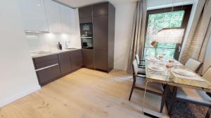 una sala da pranzo con tavolo e una cucina di White Pearl Apartment 2.08 a Timmendorfer Strand