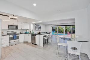 a kitchen and dining room with a table and chairs at Elegant House with Pool & Tropical Backyard in Hollywood