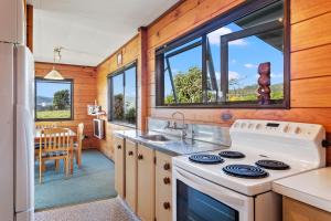 a kitchen with a stove and a sink at Airi Kainga - Seaside Escape in Te Kaha