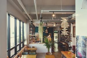 安東市にあるAndong Poong-gyung HOSTEL n LIBRARYの木製のテーブルと椅子、窓のあるレストラン