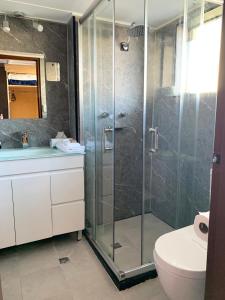 a bathroom with a shower, sink, and toilet at Mariners on the Waterfront in Batemans Bay