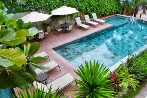 an outdoor pool with chairs and tables and umbrellas at Club do Balanço Pousada e Restaurante in Morro de São Paulo