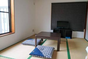 Camera piccola con tavolo e TV di guest house komoriya a Matsumoto