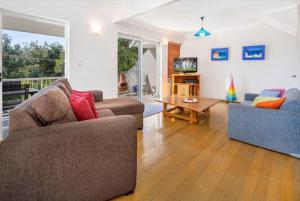 a living room with two couches and a table at Kendall Beach Apartments 5 - Belongil Beach in Byron Bay