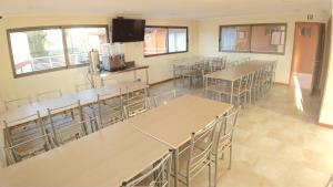 una habitación vacía con mesas, sillas y ventanas en Hotel Doña Esperanza, en Calama