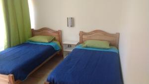 two beds sitting next to each other in a room at Hotel Doña Esperanza in Calama