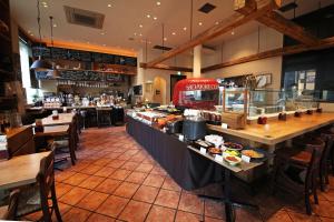 a restaurant with a counter with food on it at Hotel Keihan Tokyo Yotsuya in Tokyo