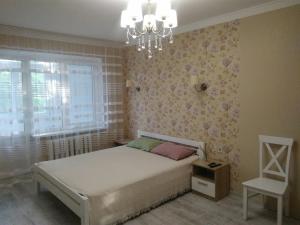 1 dormitorio con cama y lámpara de araña en Квартира у моря на Фонтане Аркадия Одесса, en Odessa
