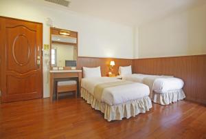 a hotel room with two beds and a mirror at 媽宮古街10號 in Magong