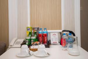 Rex Hotel Vung Tau في فنغ تاو: طاولة مع زجاجات مياه غازية وهاتف