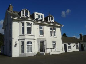a white house with white windows on a street at Seaview Wellness Retreat and Guesthouse in Carnoustie