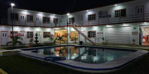 a building with a swimming pool at night at Hotel Villa Marán Chachalacas Ambiente Familiar in Chachalacas
