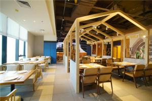 une salle à manger avec des tables et des chaises en bois dans l'établissement Atour Hotel Guangzhou Yueqiao Branch, à Canton