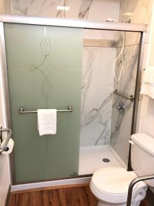 y baño con ducha de cristal y aseo. en Motel 6-Parkersburg, WV en Parkersburg