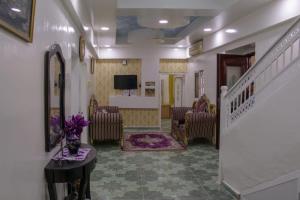 a living room with chairs and a hallway with a staircase at Al Naaman Bin Al Munther Guest House in Nizwa