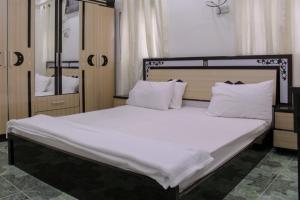 a bedroom with a large bed with white sheets and pillows at Al Naaman Bin Al Munther Guest House in Nizwa