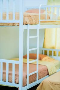 three bunk beds in a room with a bed at Nadpob Mansion in Surat Thani