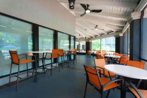 uma sala de jantar com mesas, cadeiras e janelas em La Quinta by Wyndham Ft. Myers - Sanibel Gateway em Fort Myers