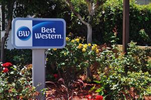 una señal azul que dice mejor occidental en un jardín en Best Western Rose Garden Inn, en Watsonville