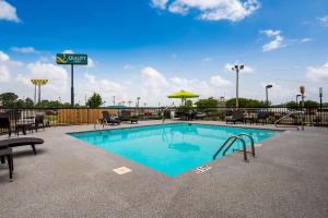 una piscina con mesas y sillas en un complejo en Quality Inn, en Cullman