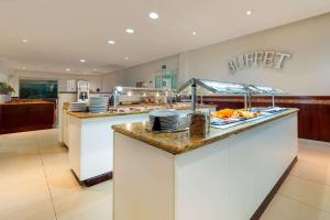 a buffet line in a restaurant with plates and food at Comfort Inn Monterrey Norte in Monterrey