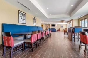 une salle à manger avec des chaises et un mur bleu dans l'établissement Comfort Inn & Suites, à Napanee