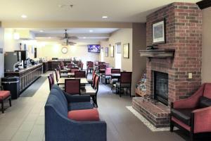 a restaurant with a fireplace and chairs and a bar at Comfort Inn & Suites St Louis - Chesterfield in Chesterfield