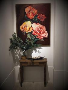 a table with a painting of roses on the wall at Alberta B&B in La Rioja