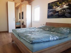 1 cama en un dormitorio con una pintura en la pared en Ferienhaus Löh, en Kleinmaischeid