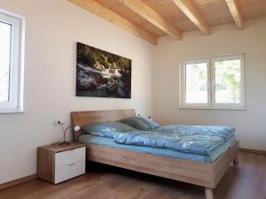 ein Schlafzimmer mit einem Bett und zwei Fenstern in der Unterkunft Ferienhaus Löh in Kleinmaischeid
