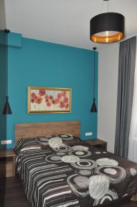 1 dormitorio con 1 cama con pared azul en Къща за гости Ирис en Kyustendil