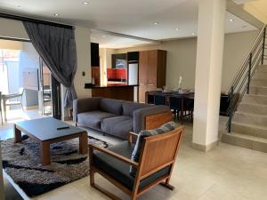 a living room with a couch and a table at 66 Dorp Street Apartment in Polokwane