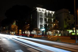 een stadsstraat 's nachts met een gebouw met verlichting bij Hotel Vela D'Oro in Riccione