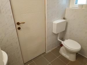 a bathroom with a white toilet and a sink at Vivienne Apartment in Zamárdi +15 photos